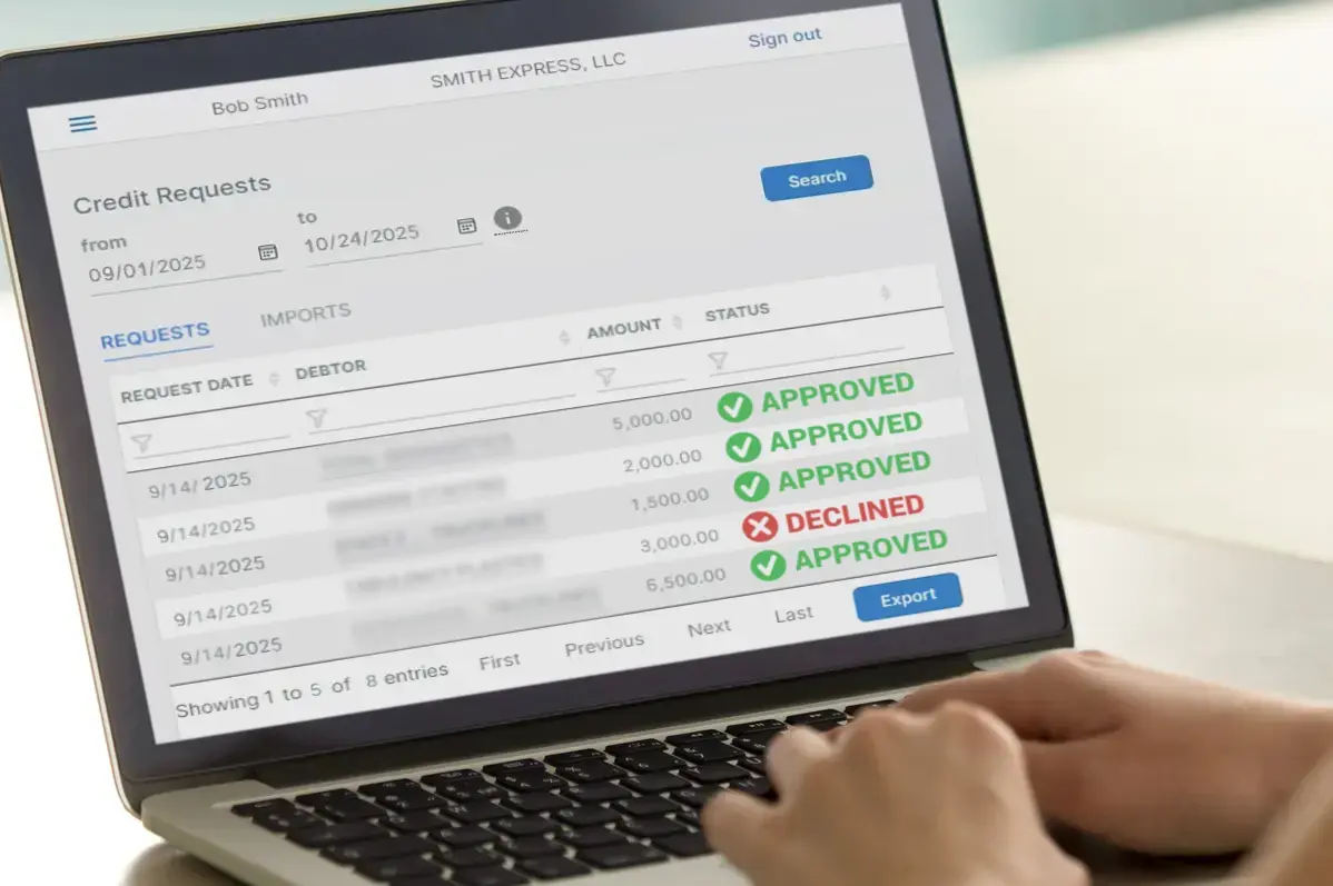 Hands on Computer keyboard screen showing invoice credit approvals and denial.